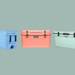Top-rated outdoor coolers of 2025 stacked at a scenic camping site with ice and beverages inside